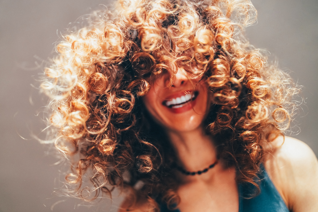 Woman with curly hair taking selfie Picture of a smiling woman
